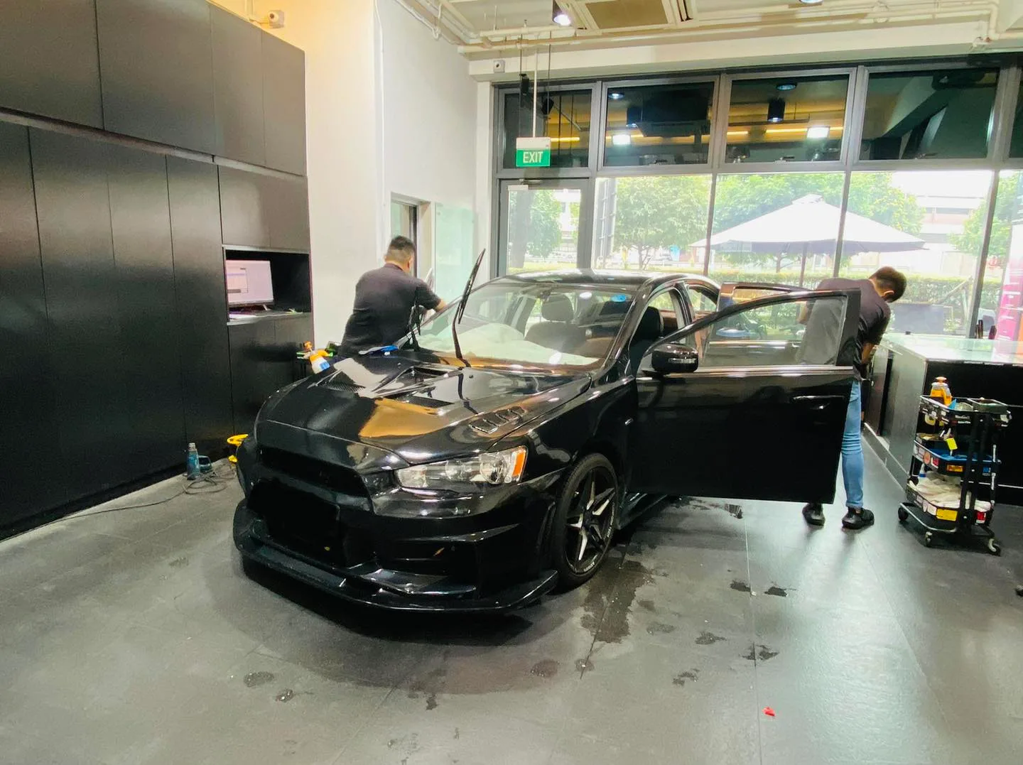 Black Mitsubishi Lancer Evo being window tinted at Infratint Singapore