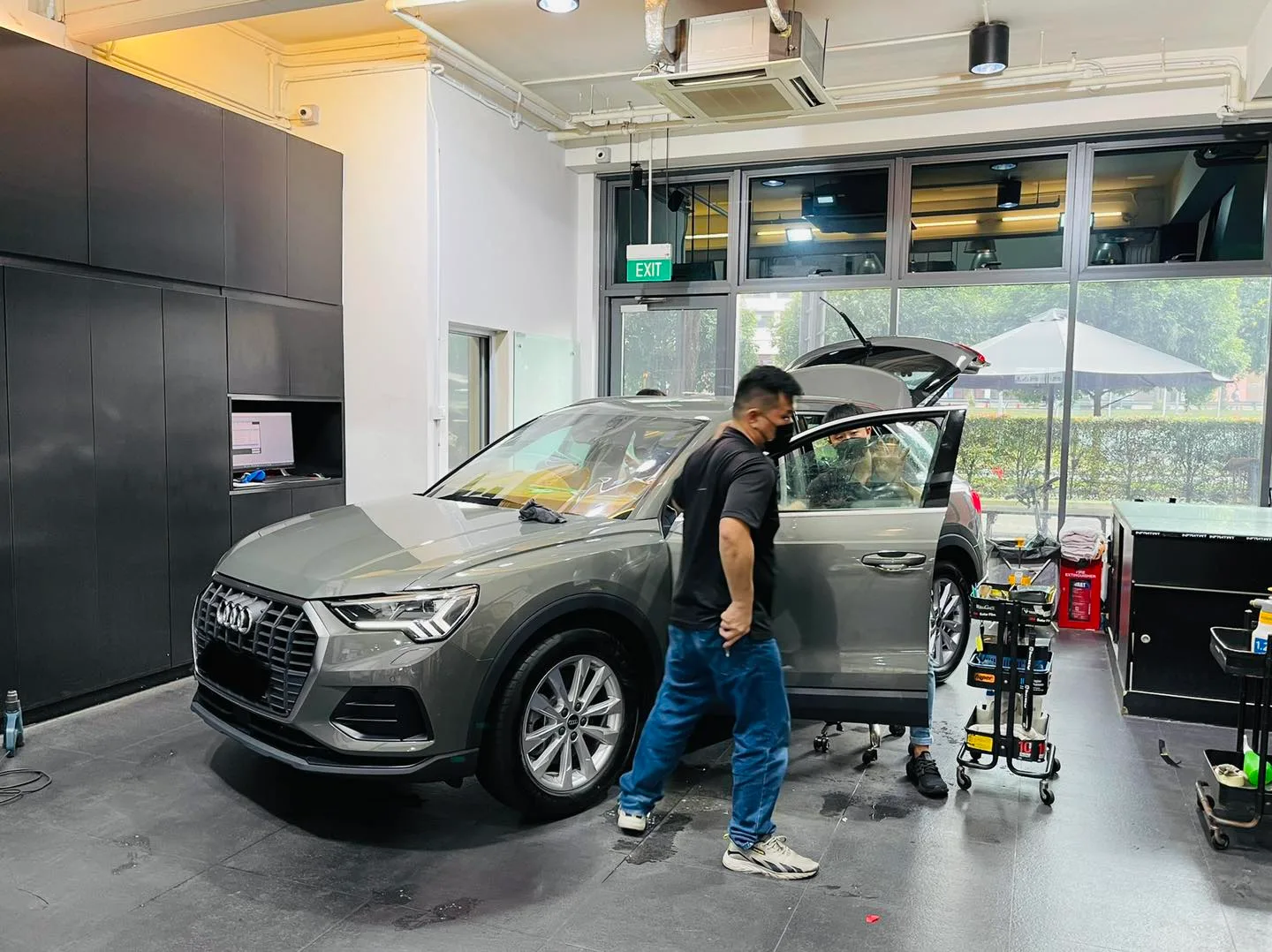 Grey Audi Q3 SUV being window tinted by a technician at Infratint Singapore
