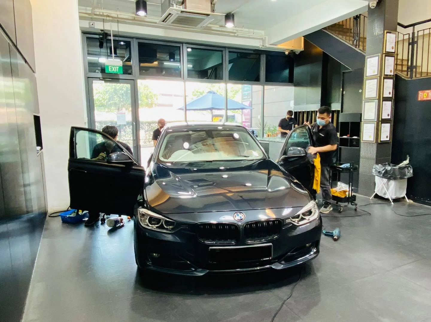 Black BMW sedan with door open during window tinting at Infratint Singapore