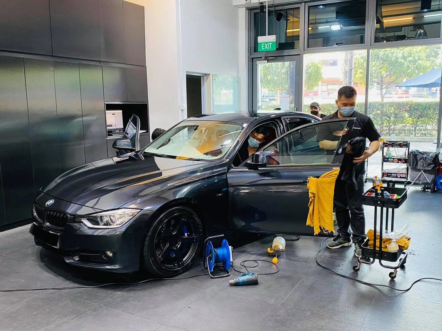 Dark grey BMW sedan with blue calipers being tinted at Infratint Singapore