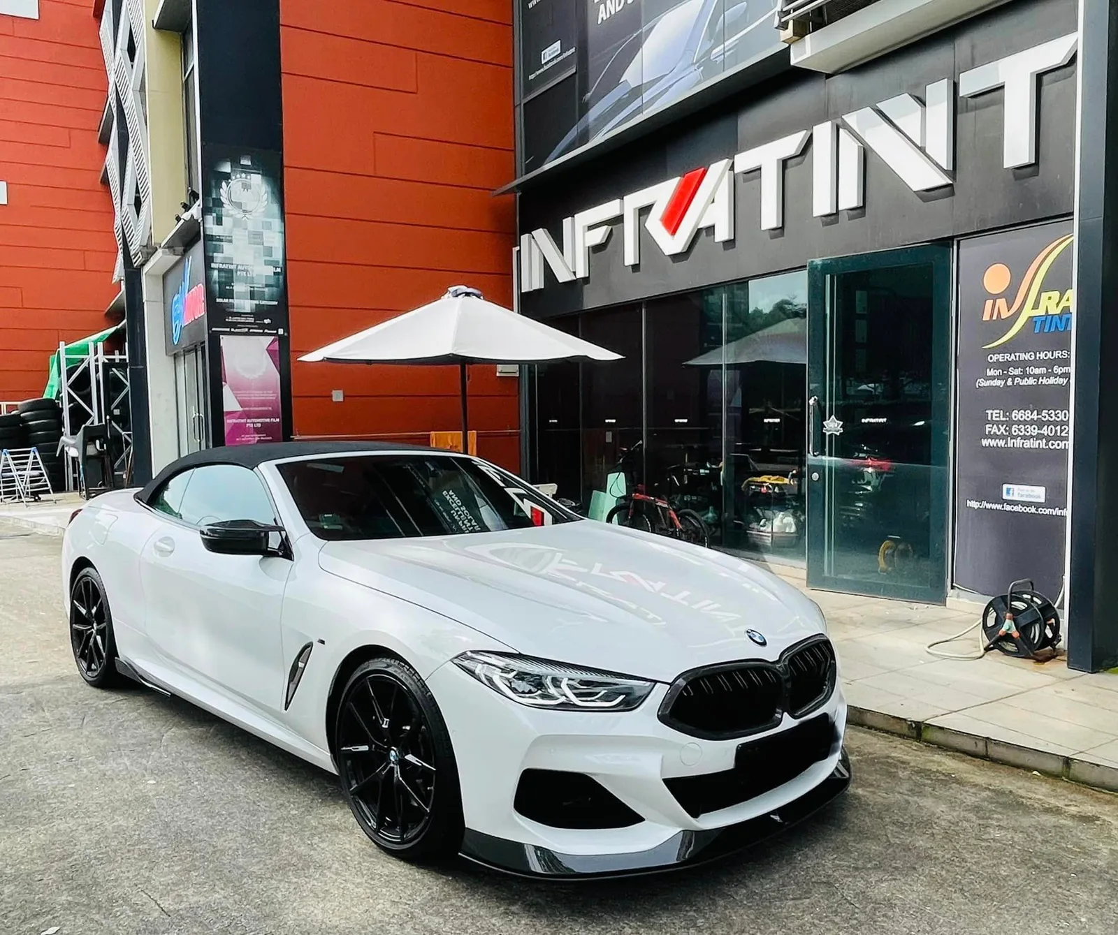 White BMW 8 Series convertible outside the Infratint Singapore shopfront