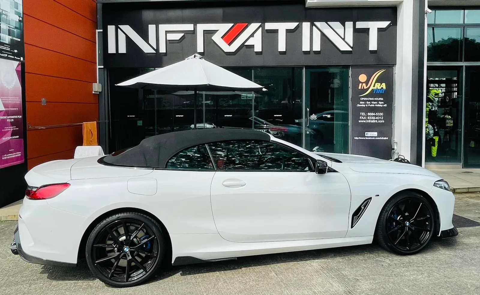 Side profile of a white BMW 8 Series convertible outside Infratint Singapore