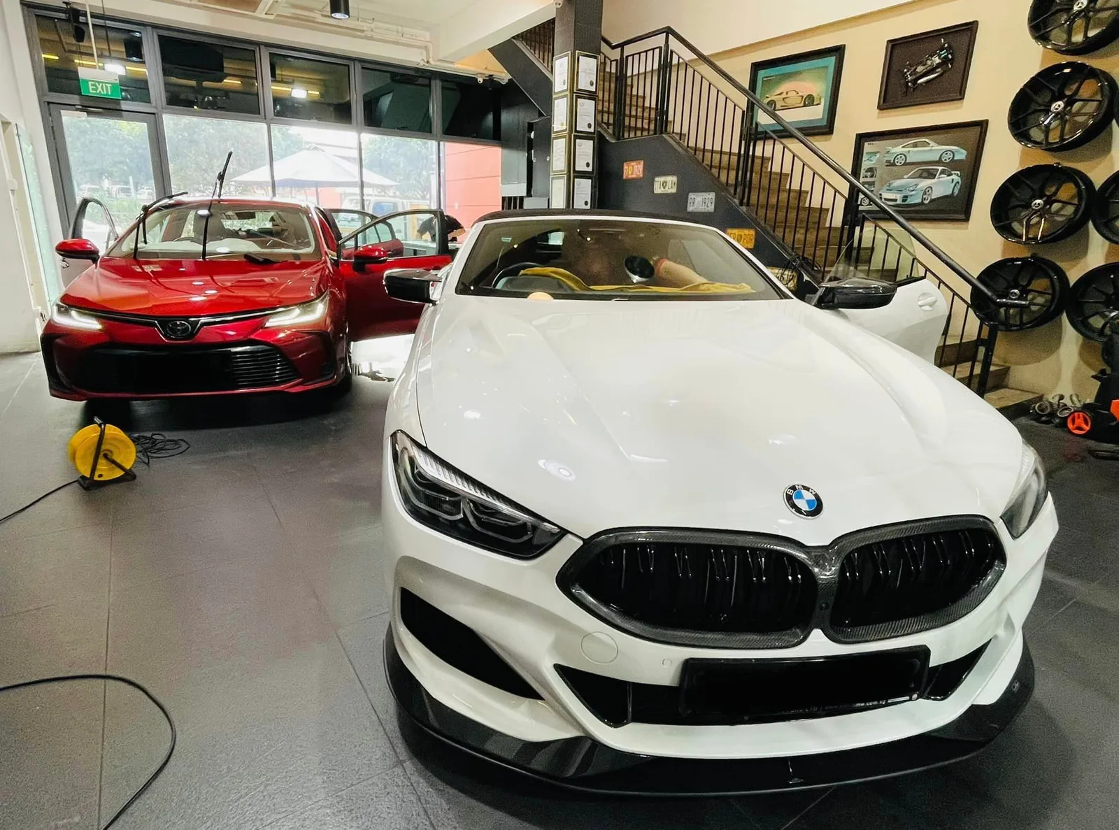 White BMW 8 Series and a red Toyota sedan inside the Infratint Singapore showroom