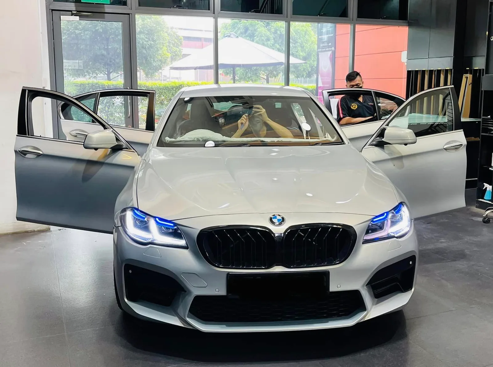 Silver BMW 5 Series front view with doors open during tinting at Infratint Singapore