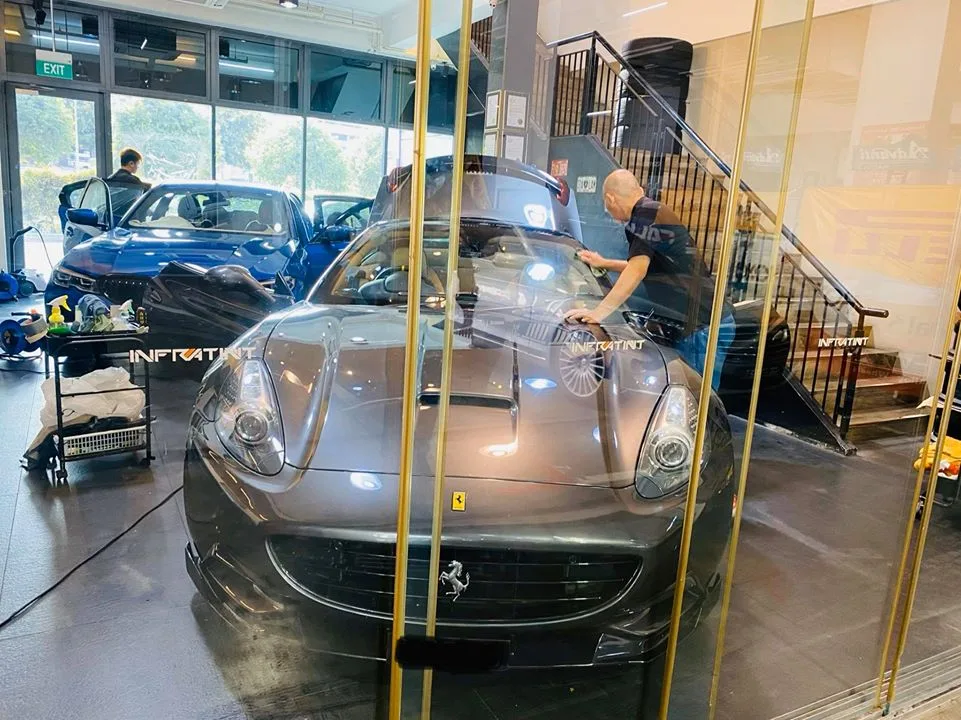 Grey Ferrari California convertible and a blue BMW inside Infratint Singapore for window tinting