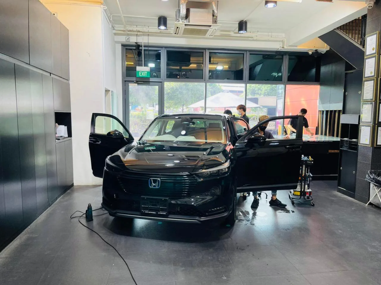Black Honda SUV with doors open during window film installation at Infratint Singapore