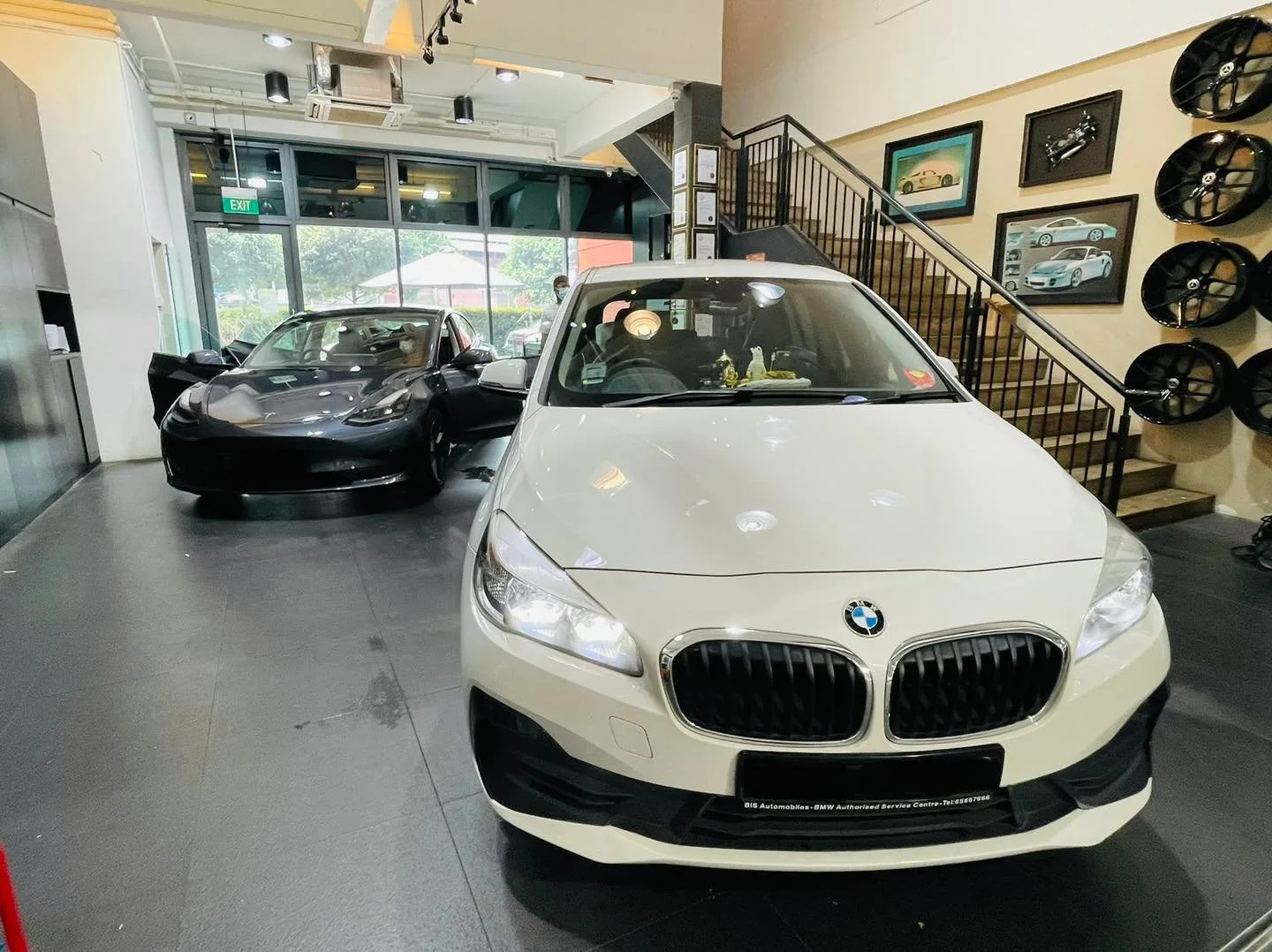 White BMW and a dark Tesla inside the Infratint Singapore showroom