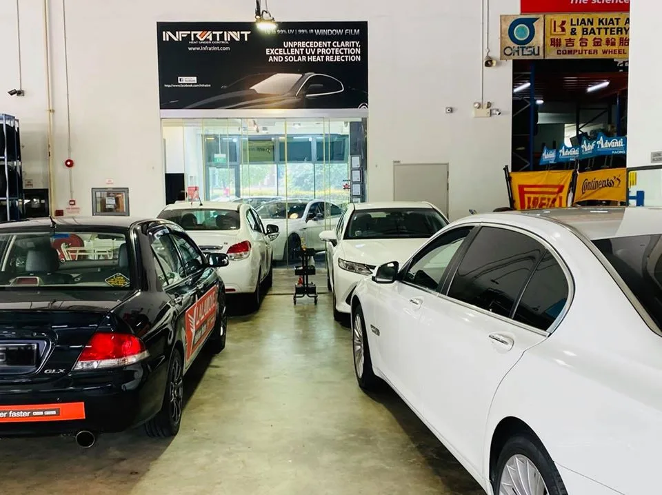 Black Mitsubishi Lancer and white BMW 7 Series at Infratint Singapore for tinting