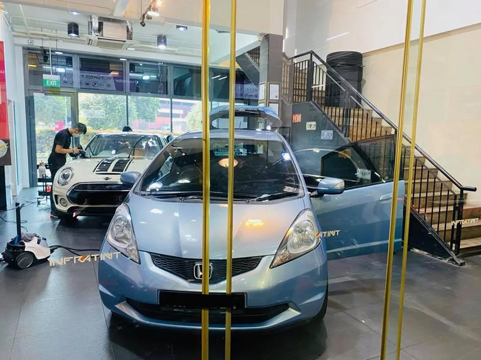Light blue Honda Fit and white Mini Cooper at Infratint Singapore