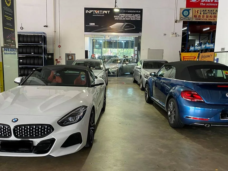 White BMW Z4 roadster and blue VW Beetle convertible at Infratint Singapore