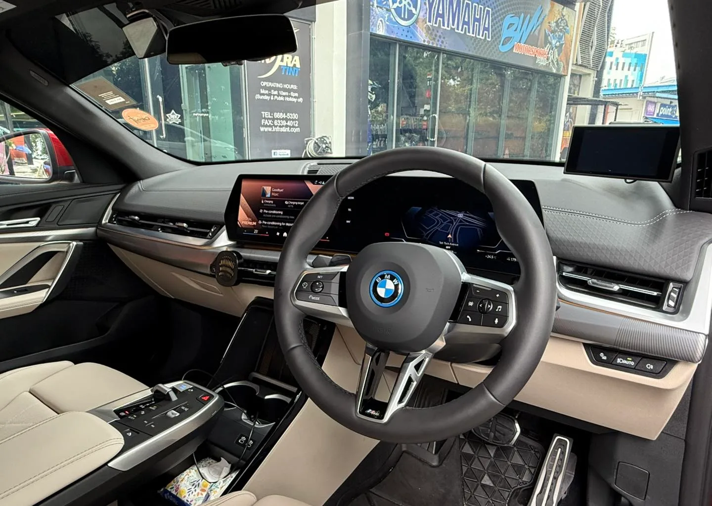 BMW iX2 curved display and steering wheel seen through tinted windscreen at Infratint Singapore