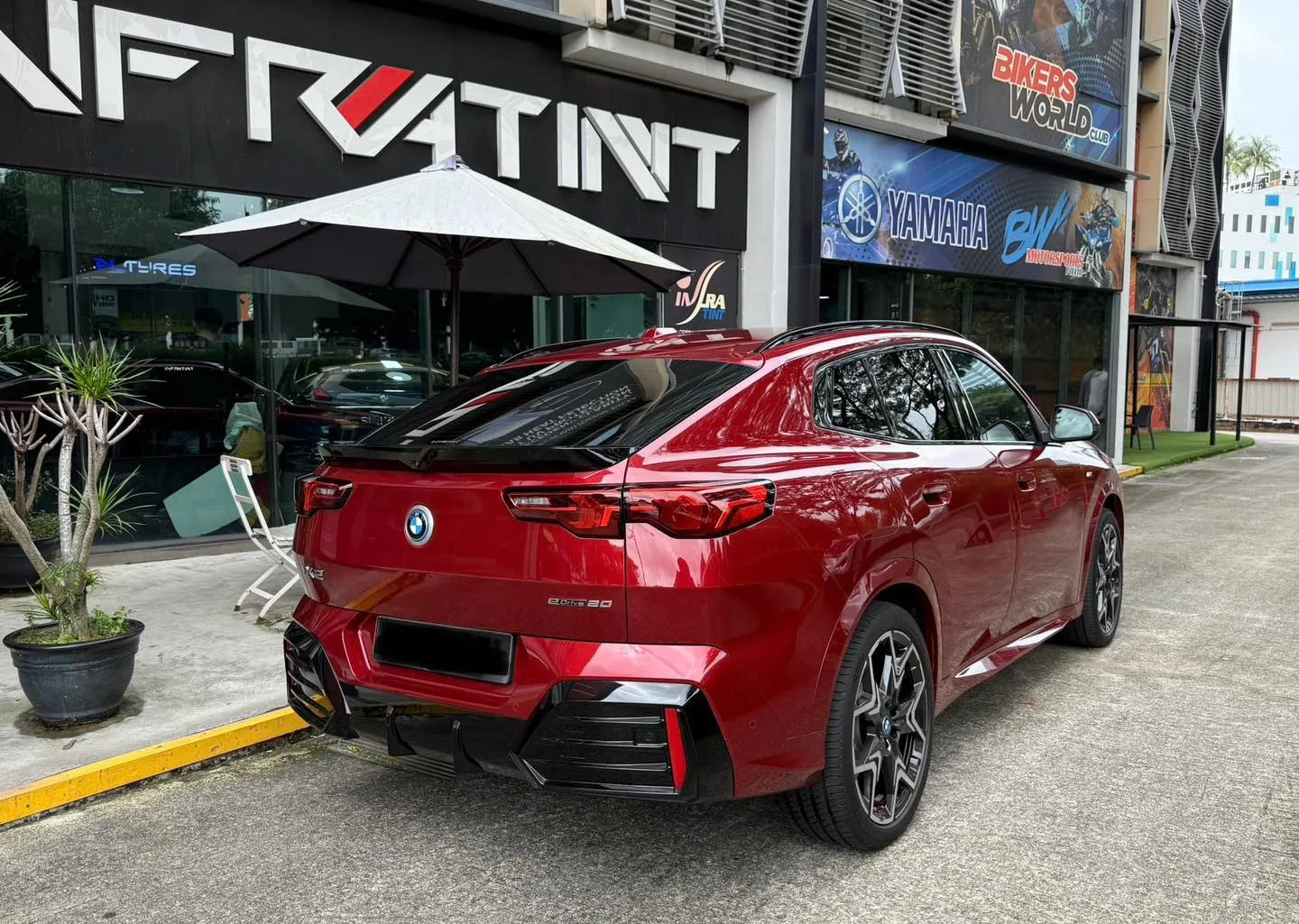 Red BMW iX2 rear three-quarter view with tinted glass at Infratint Singapore