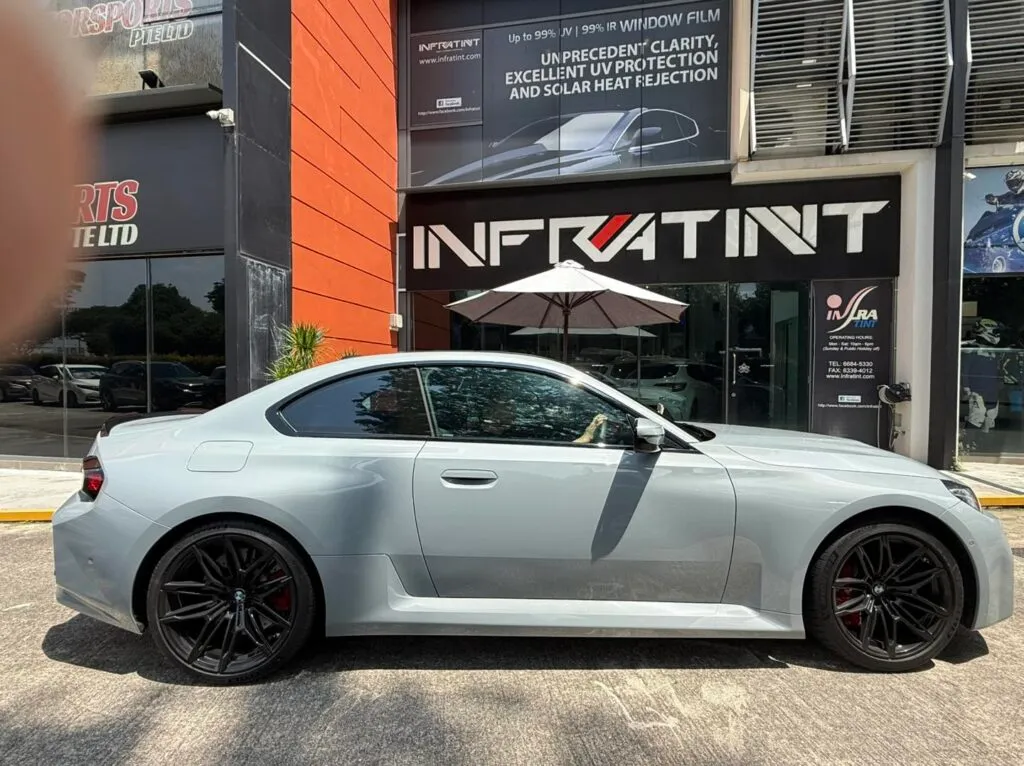 Tinted grey BMW M2 side profile outside the Infratint shopfront in Singapore