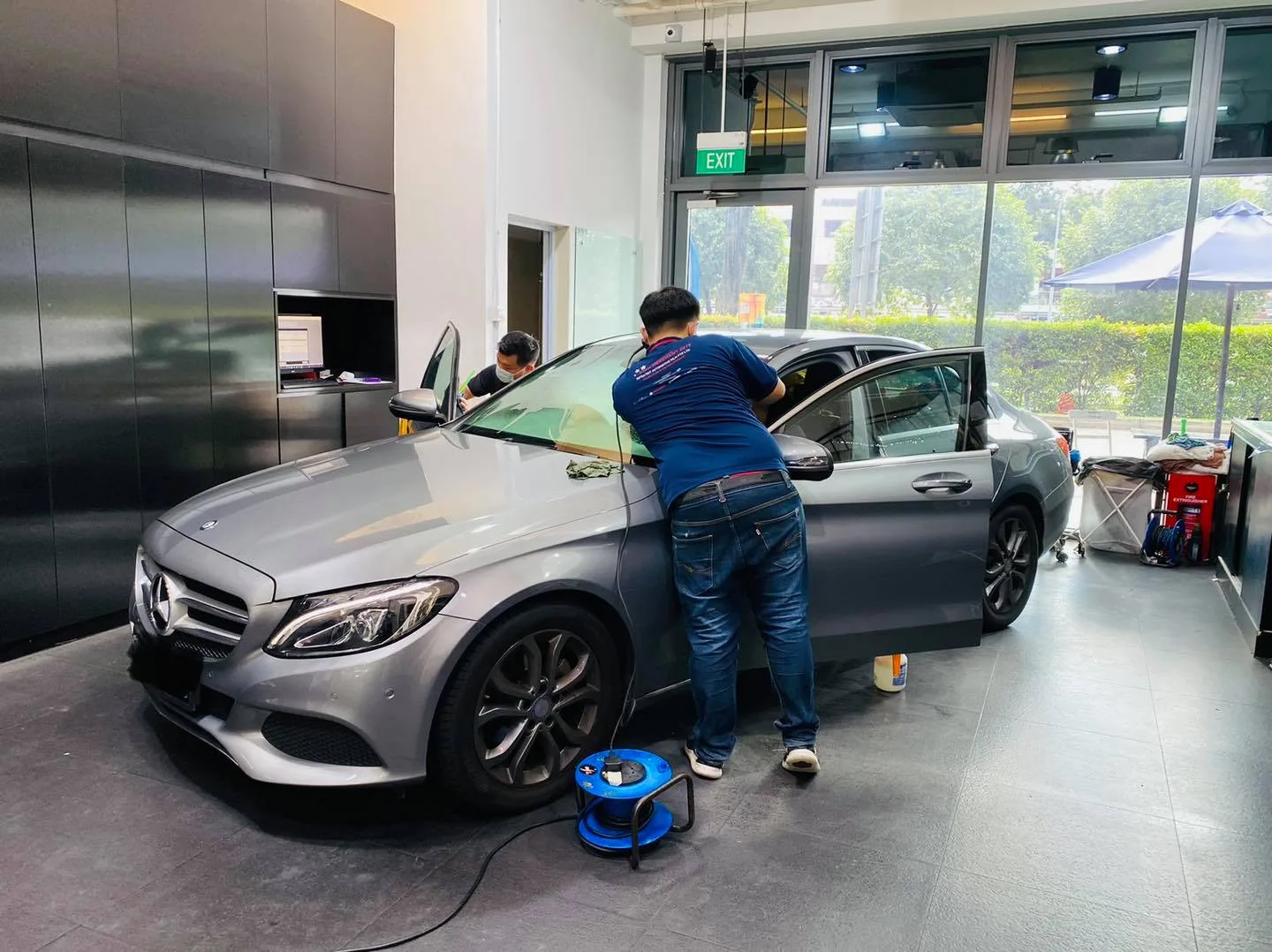 Installer tinting the windscreen of a grey Mercedes-Benz C-Class at Infratint Singapore