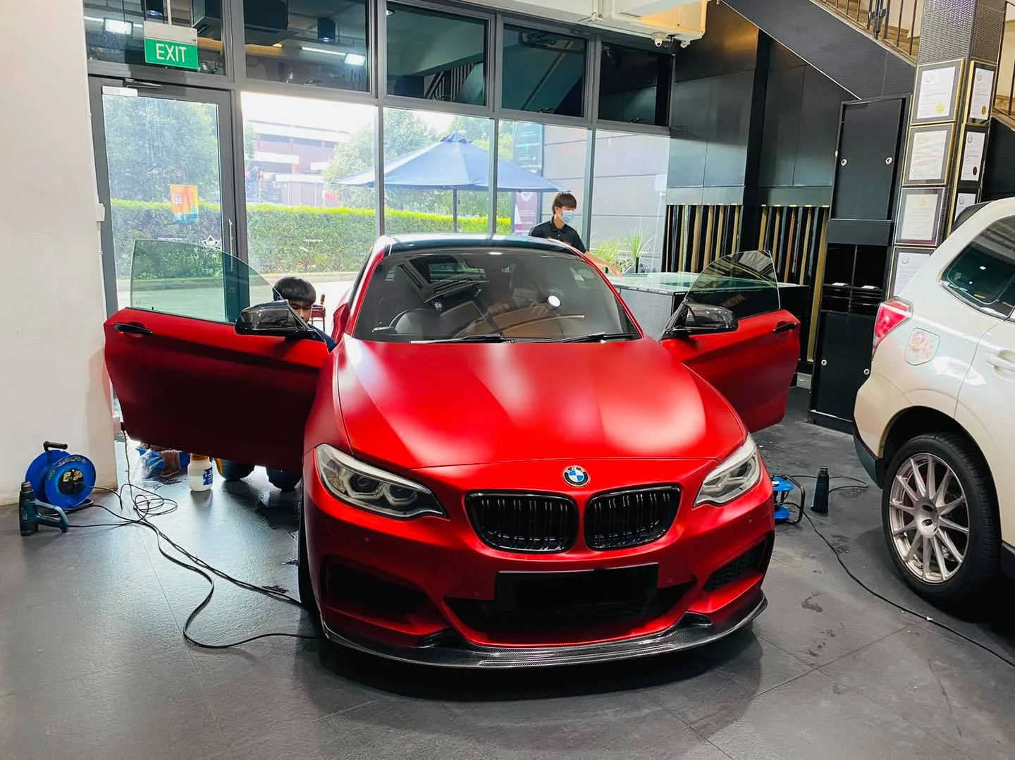 Matte red BMW coupe being tinted at Infratint Singapore