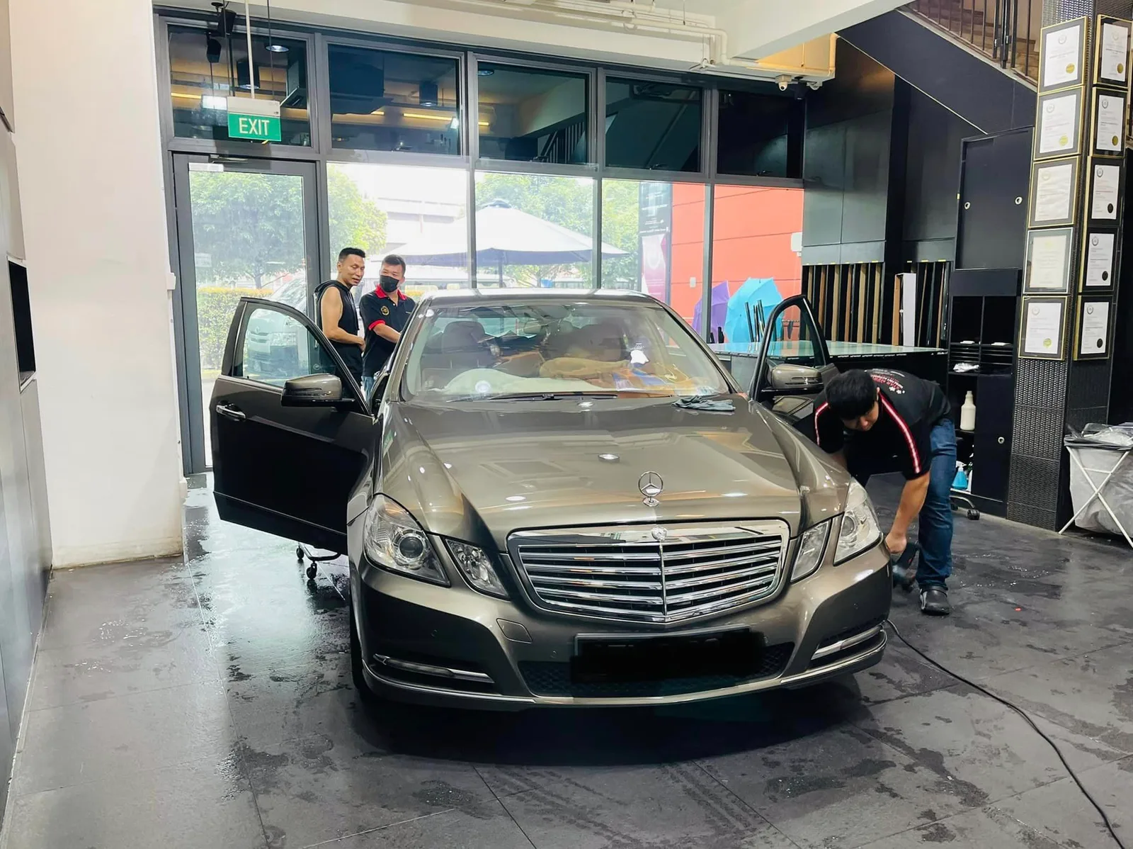 Installers tinting a bronze Mercedes-Benz E-Class at Infratint Singapore