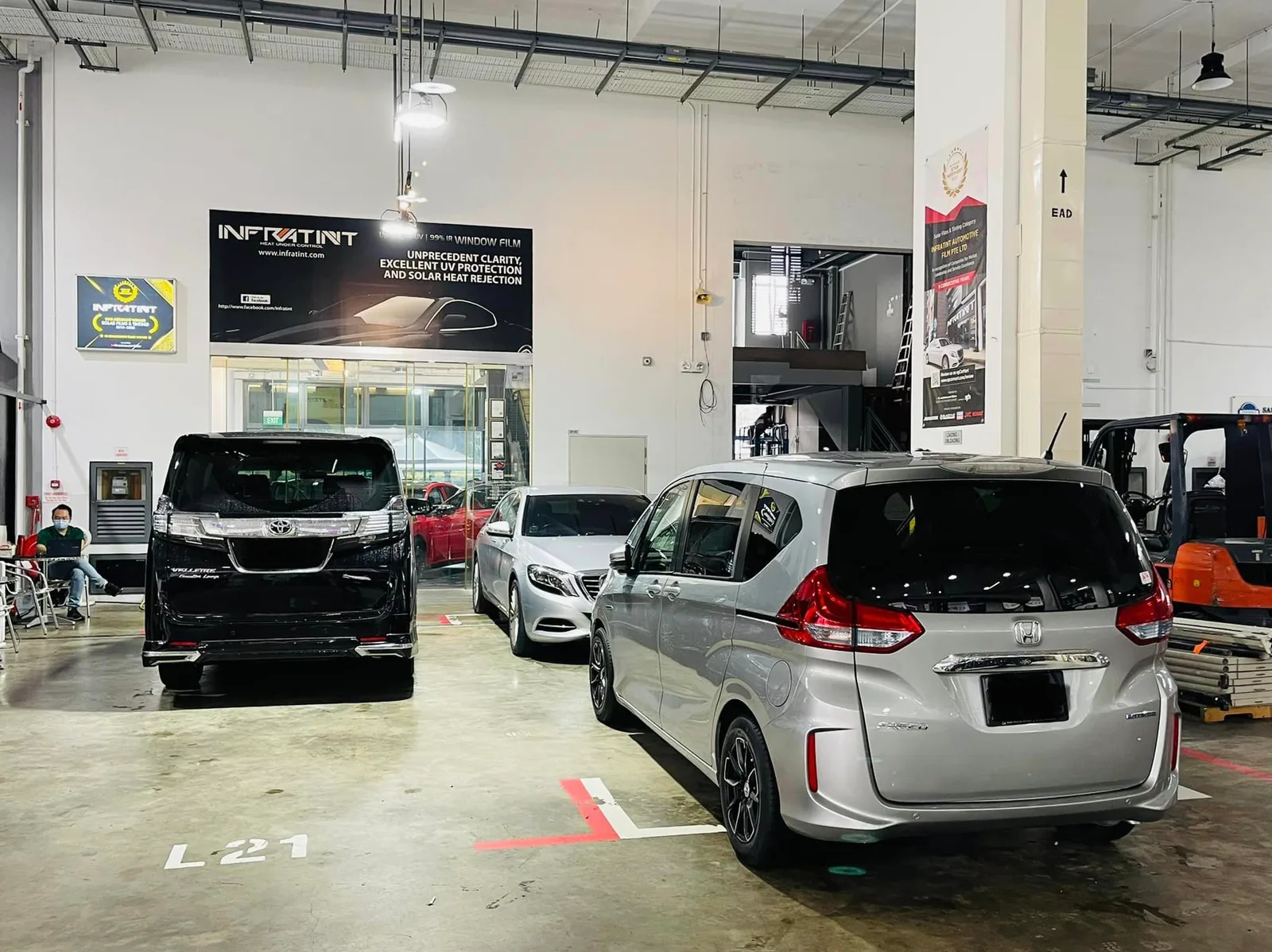 Silver Honda Freed and black Toyota Alphard inside the Infratint Singapore workshop