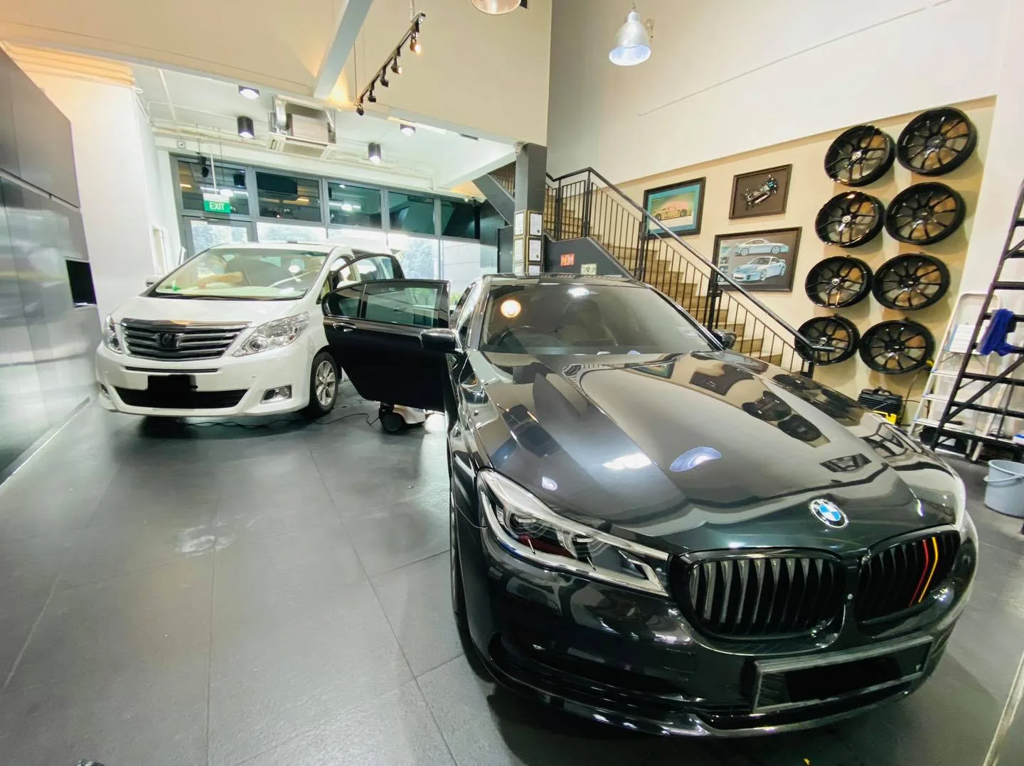 Dark green BMW 7 Series and white Toyota Alphard in the Infratint Singapore showroom for window tinting