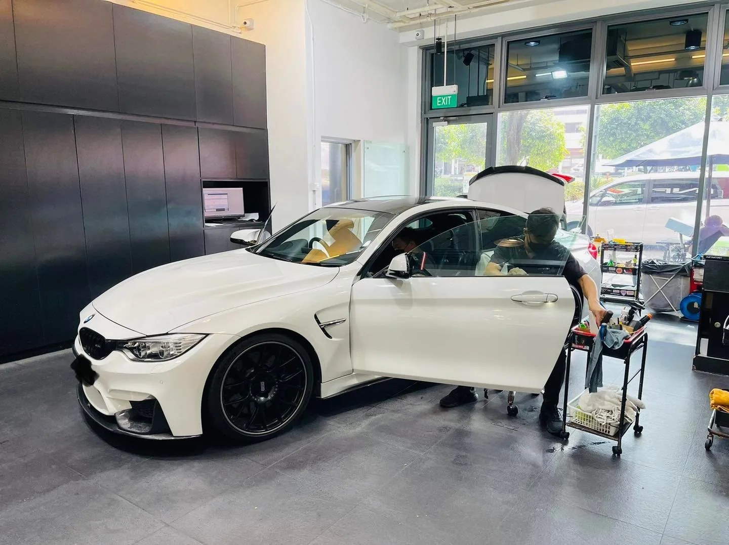 White BMW M4 coupe with boot open during solar film install at Infratint Singapore
