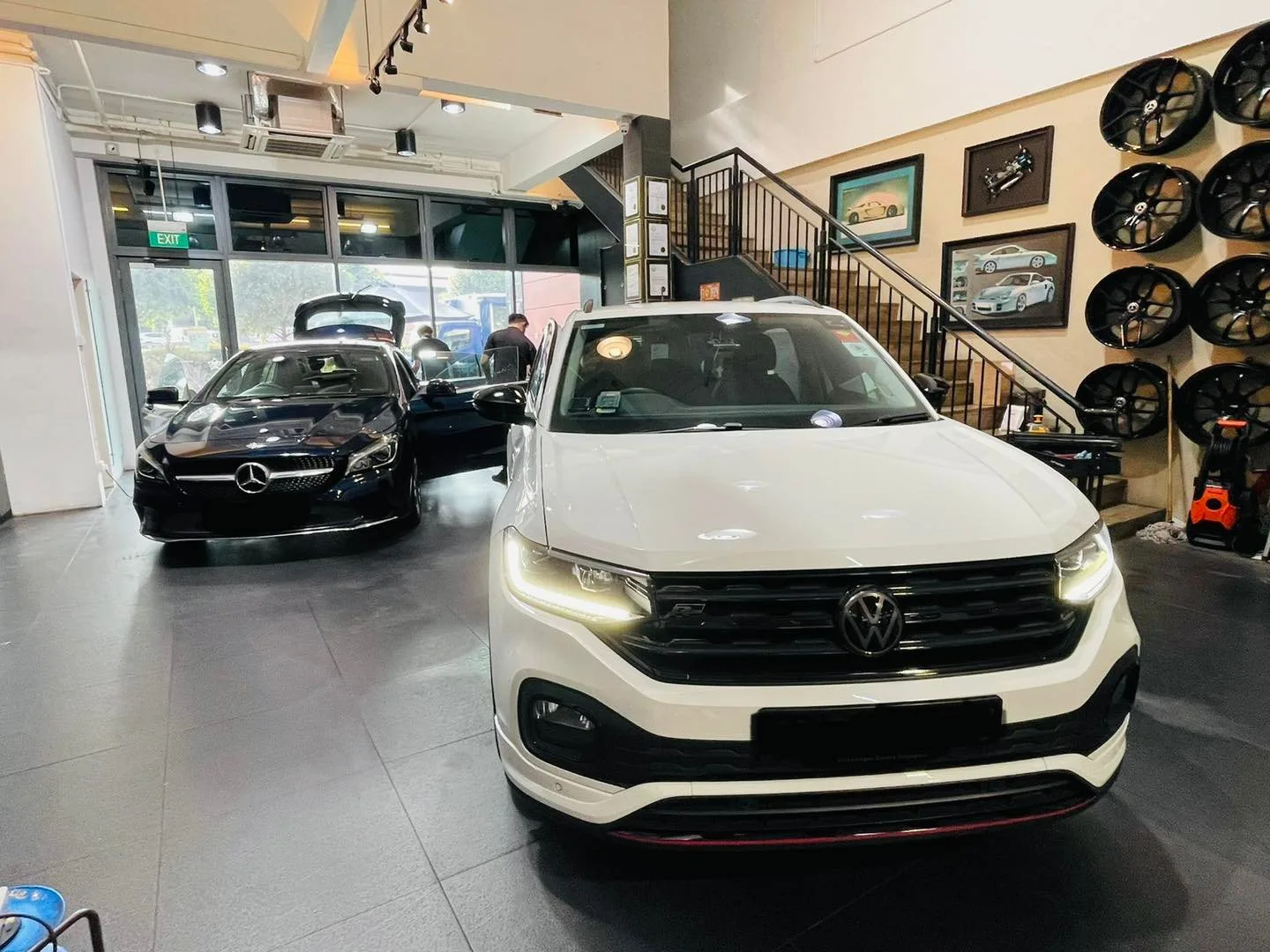 White Volkswagen crossover and a dark Mercedes-Benz CLA inside Infratint Singapore