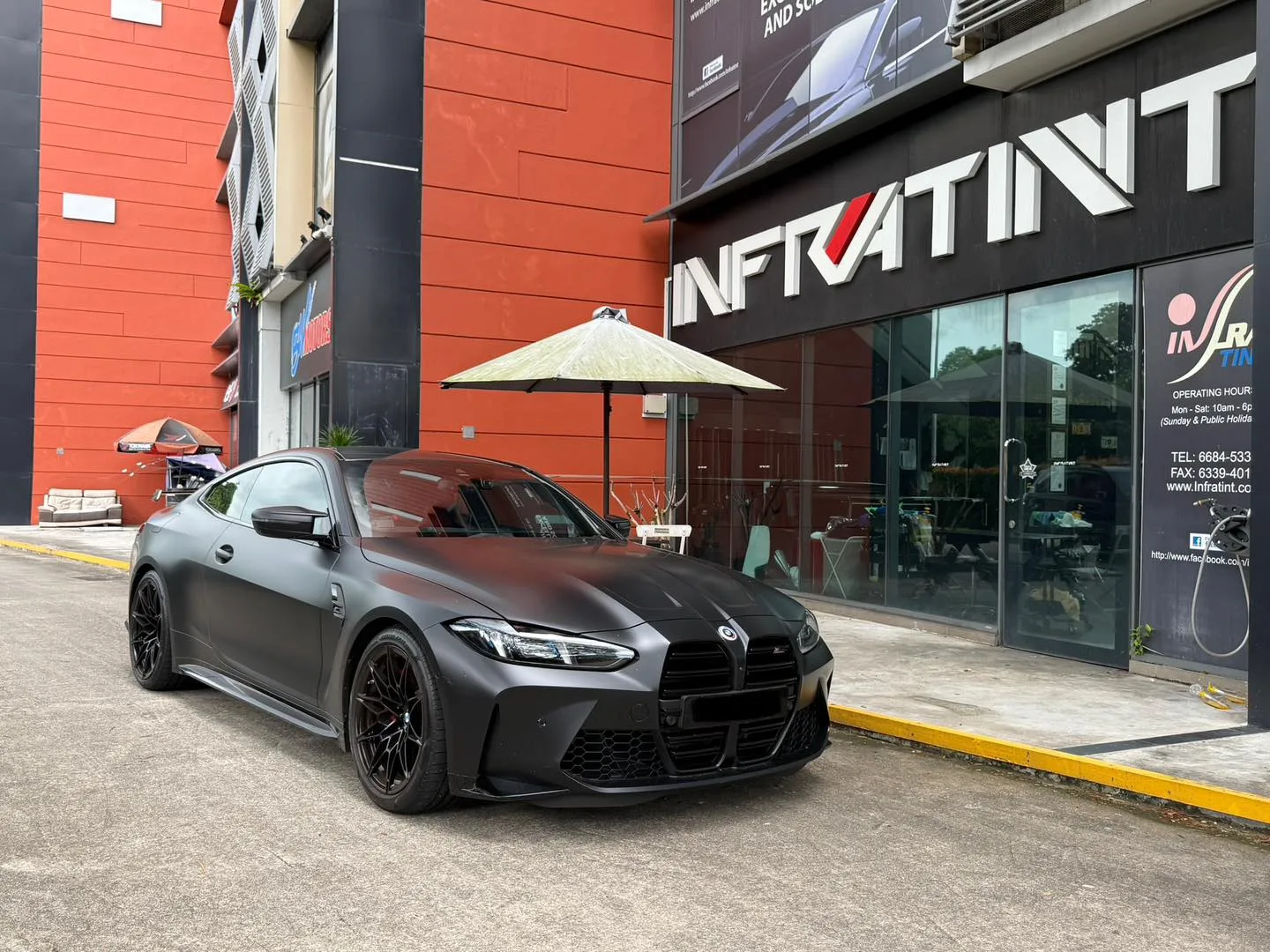 Matte grey BMW M4 Competition xDrive, front three-quarter view outside Infratint Singapore