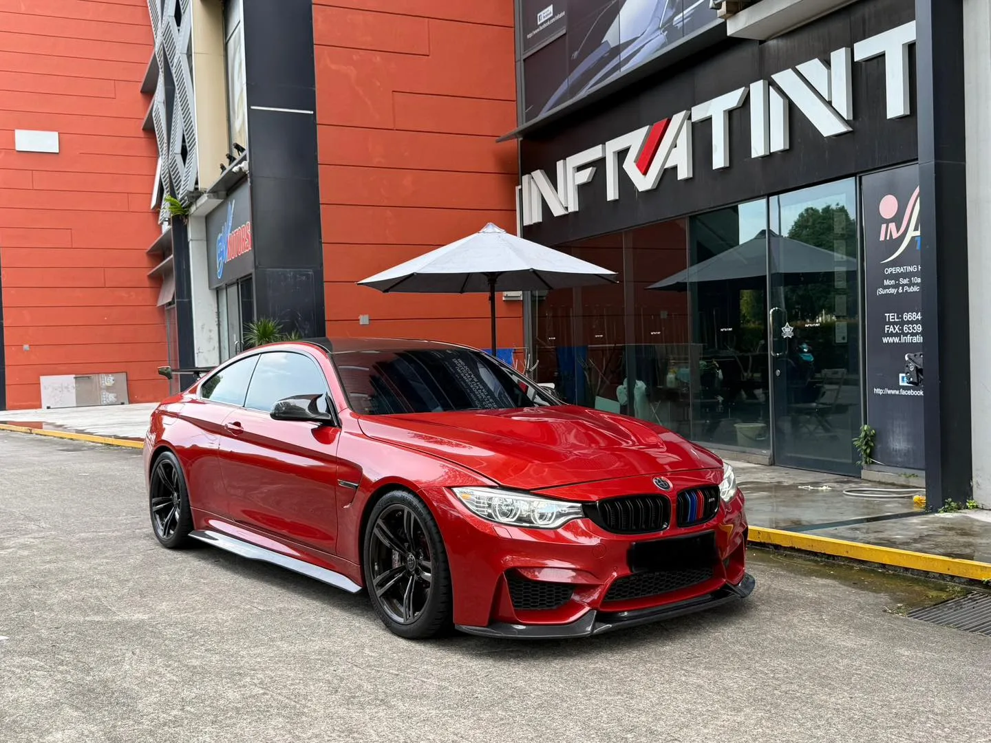 Tinted red BMW M4 front three-quarter view at Infratint Singapore