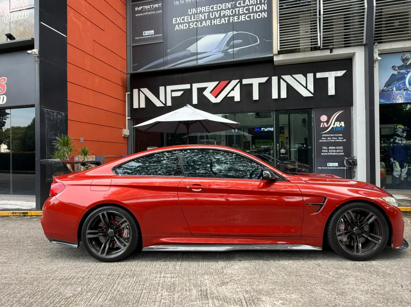 Tinted red BMW M4 side profile outside Infratint Singapore