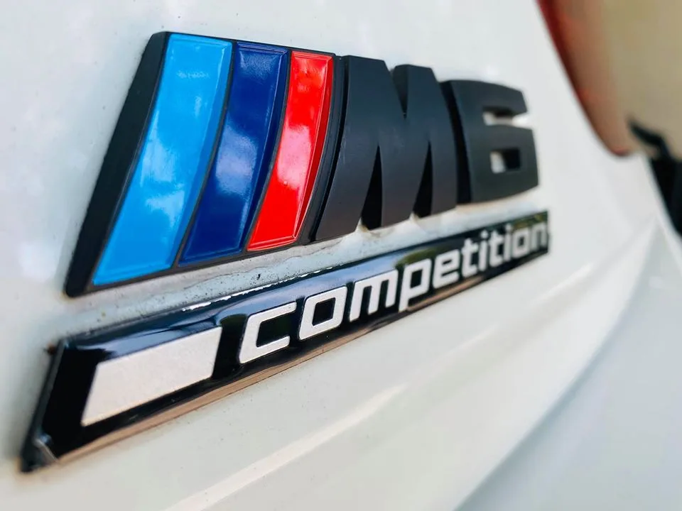 Close-up of a BMW M6 Competition rear badge at Infratint Singapore
