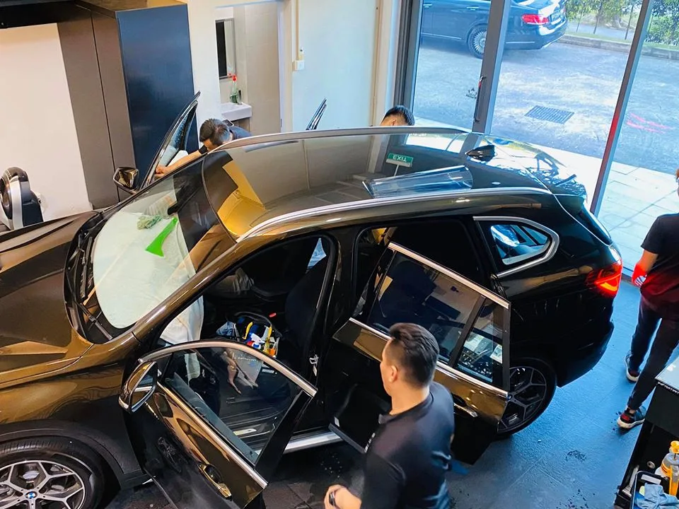 Three-quarter rear view of a black BMW SUV during window film install at Infratint Singapore