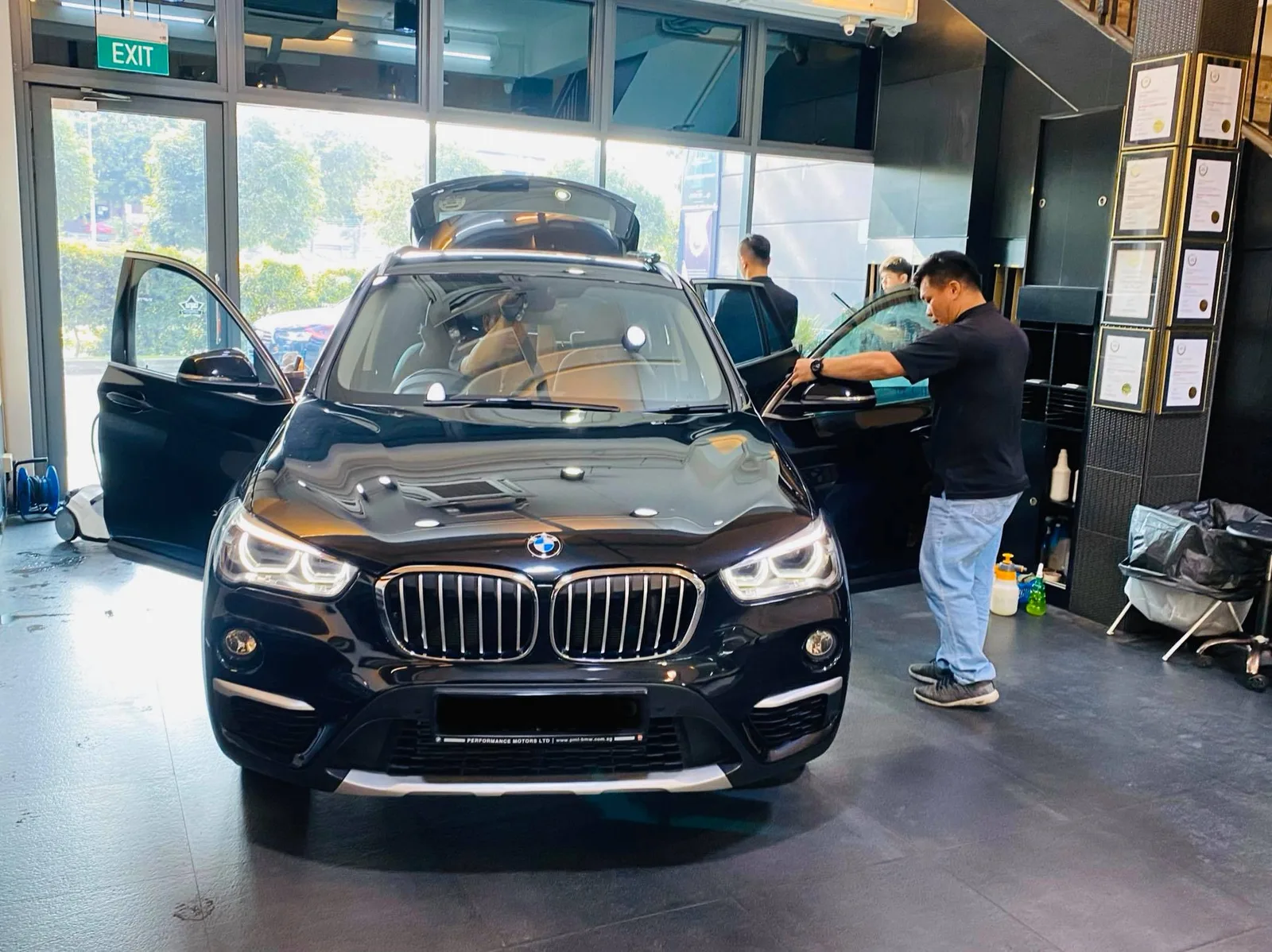Black BMW SUV with doors open during window tinting at Infratint Singapore