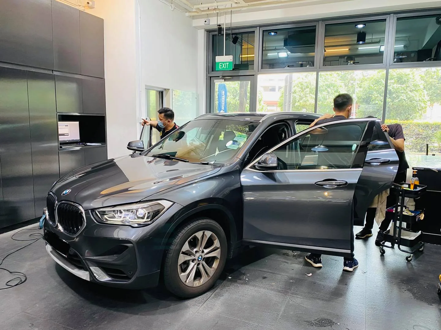 Grey BMW SUV being tinted by the install team at Infratint Singapore