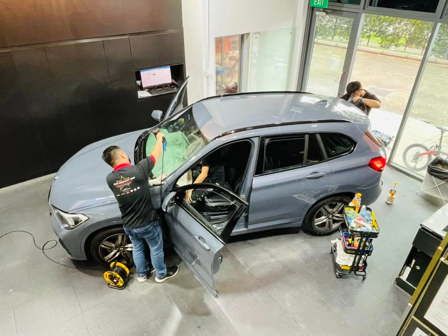Overhead view of a blue-grey BMW X1 having film heat-shaped at Infratint Singapore