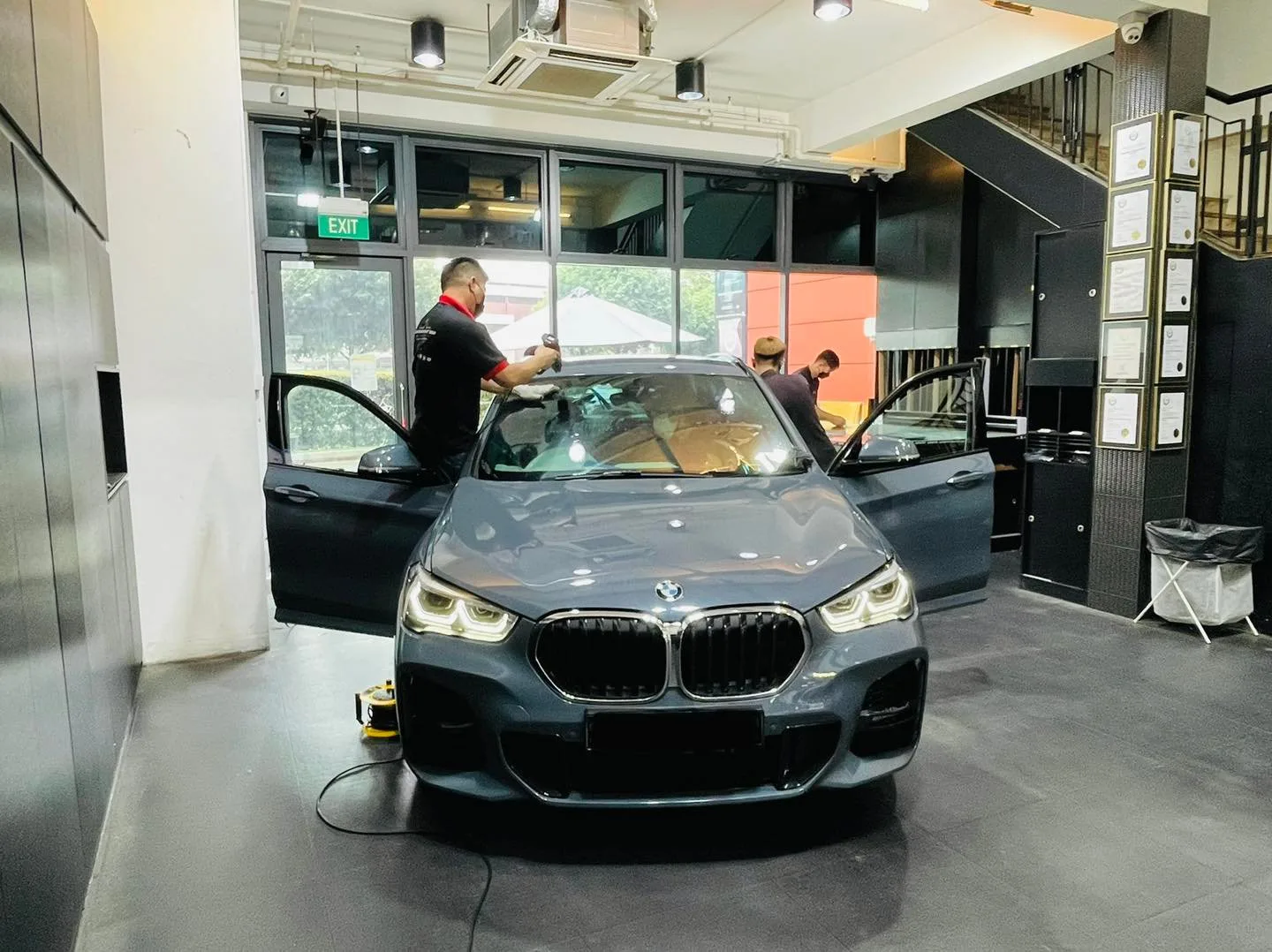 Dark grey BMW X1 SUV having its windscreen tinted at Infratint Singapore