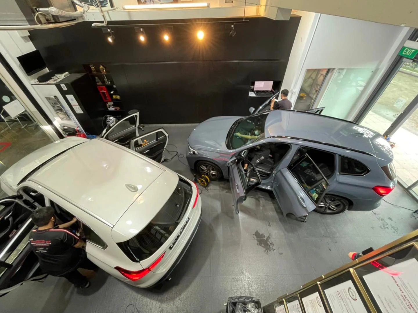 White sedan and blue-grey BMW SUV being tinted at Infratint Singapore