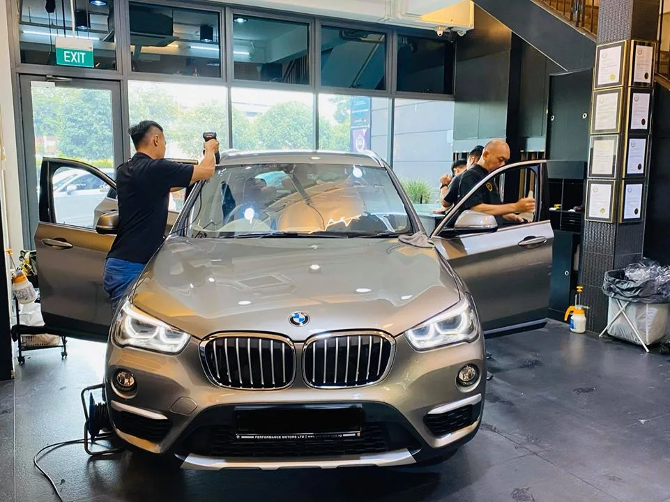 Bronze BMW X1 front view during window tinting at Infratint Singapore