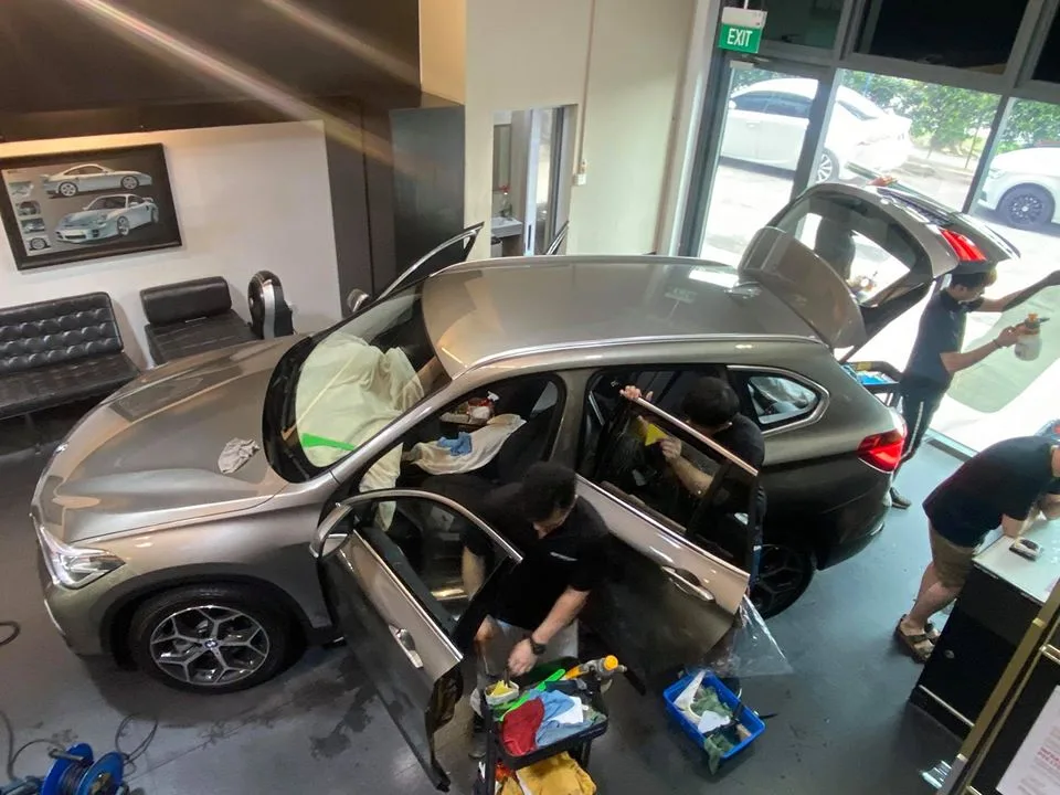 Bronze BMW X1 with doors and tailgate open during tinting at Infratint Singapore