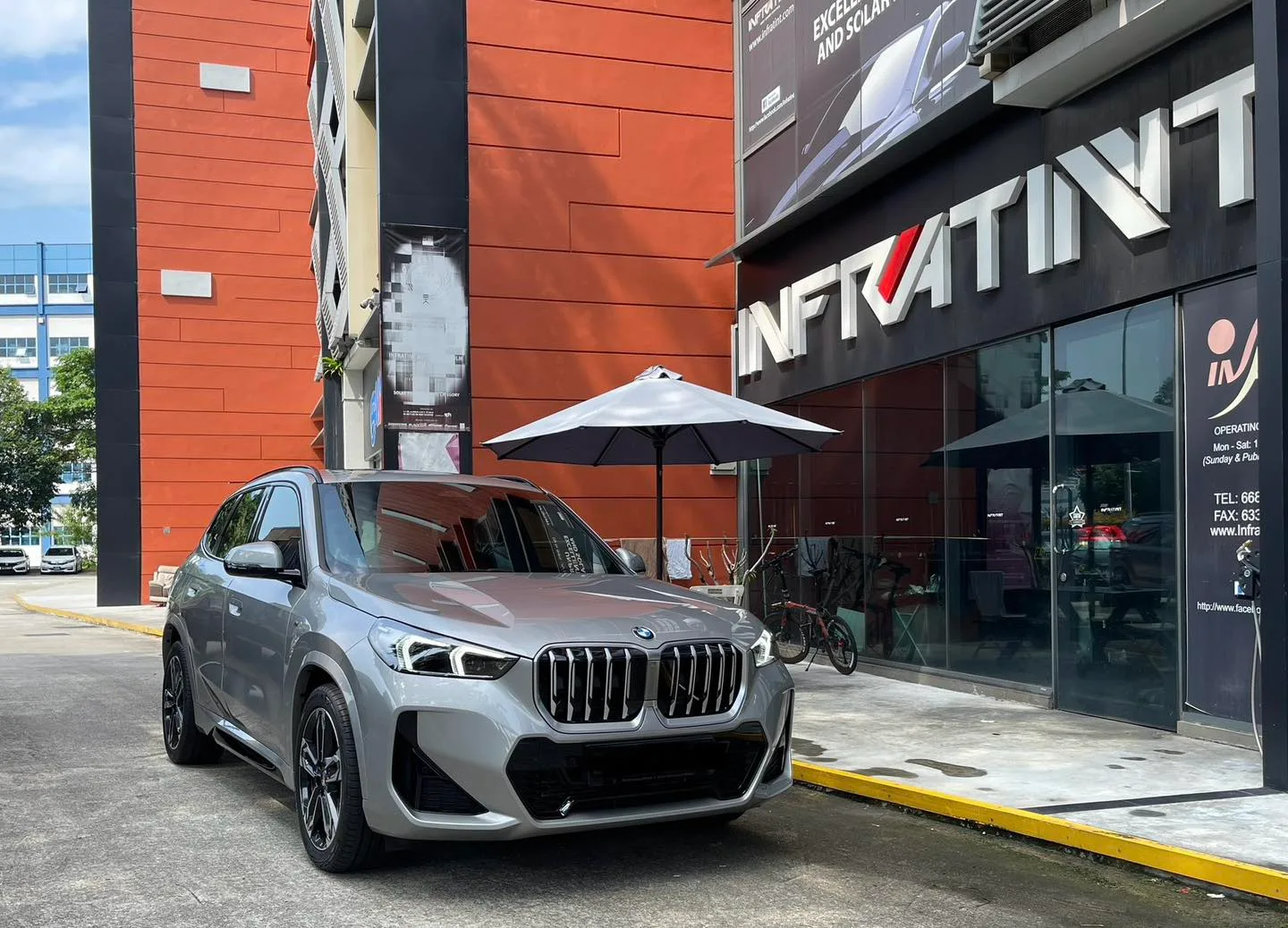 Tinted silver BMW X1 front three-quarter view outside Infratint Singapore