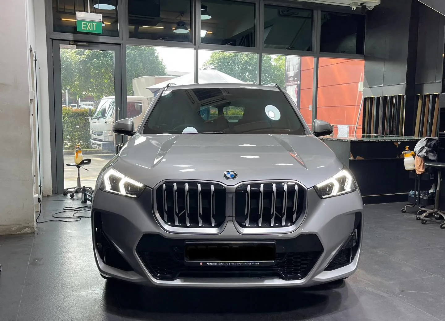 Silver BMW X1 viewed head-on inside the Infratint workshop bay