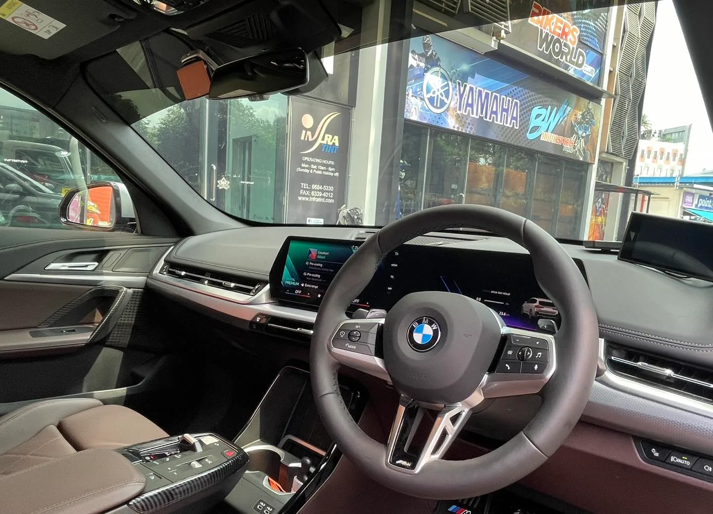 BMW X1 cockpit and curved display seen through tinted glass at Infratint Singapore