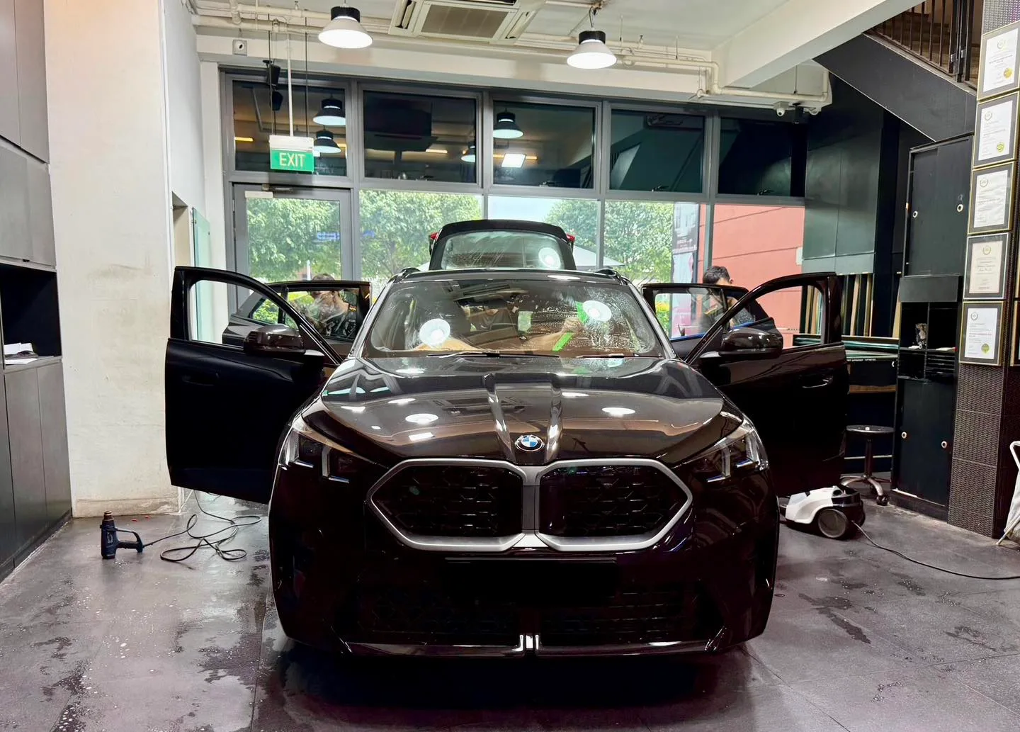 Black BMW X2 with doors open during tinting inside the Infratint workshop