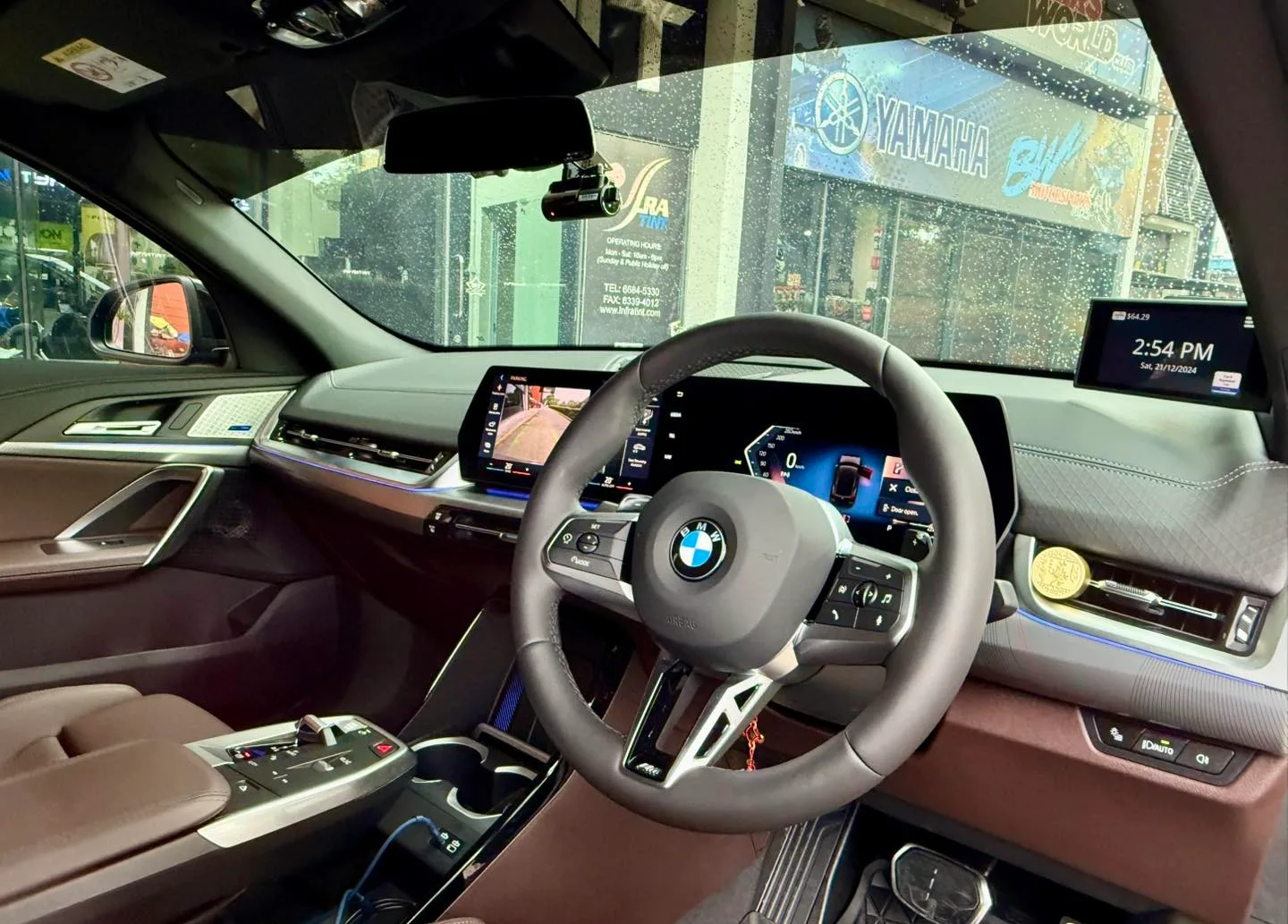 BMW X2 cockpit and curved display seen through tinted glass at Infratint Singapore