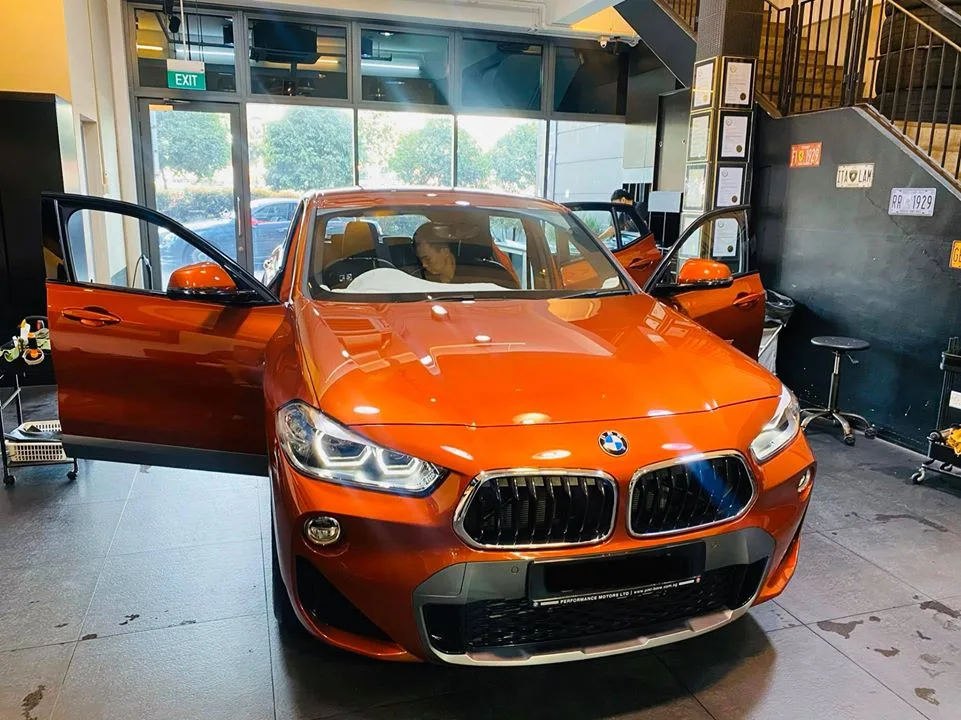 Orange BMW X2 with driver door open and orange interior at Infratint Singapore