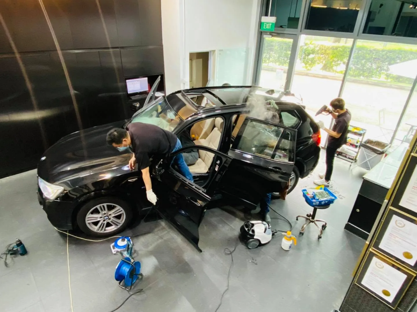 Overhead view of two installers tinting a black BMW X3 at Infratint Singapore