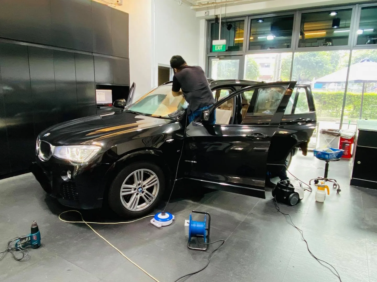 Installer applying window film to a black BMW X3 at Infratint Singapore