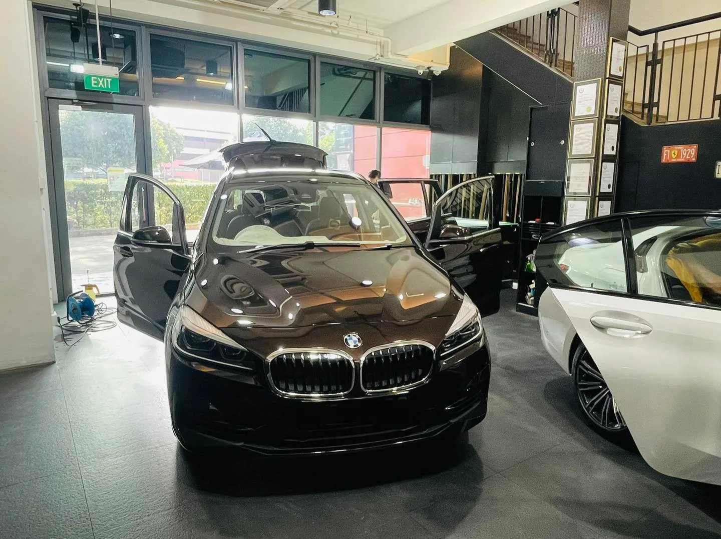 Black BMW 2 Series MPV with doors open at Infratint Singapore for window tinting