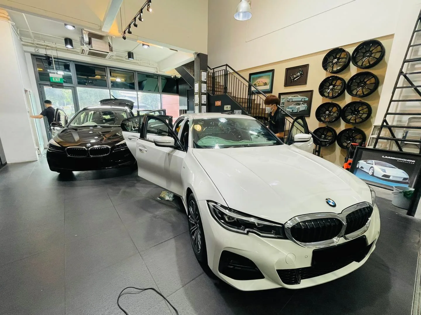White BMW 3 Series and black BMW inside the Infratint Singapore showroom for window film