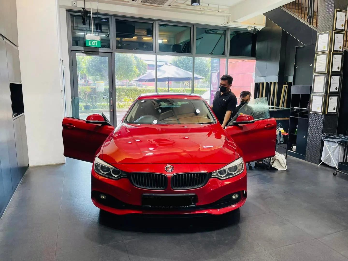 Red BMW coupe with doors open for window tinting at Infratint Singapore