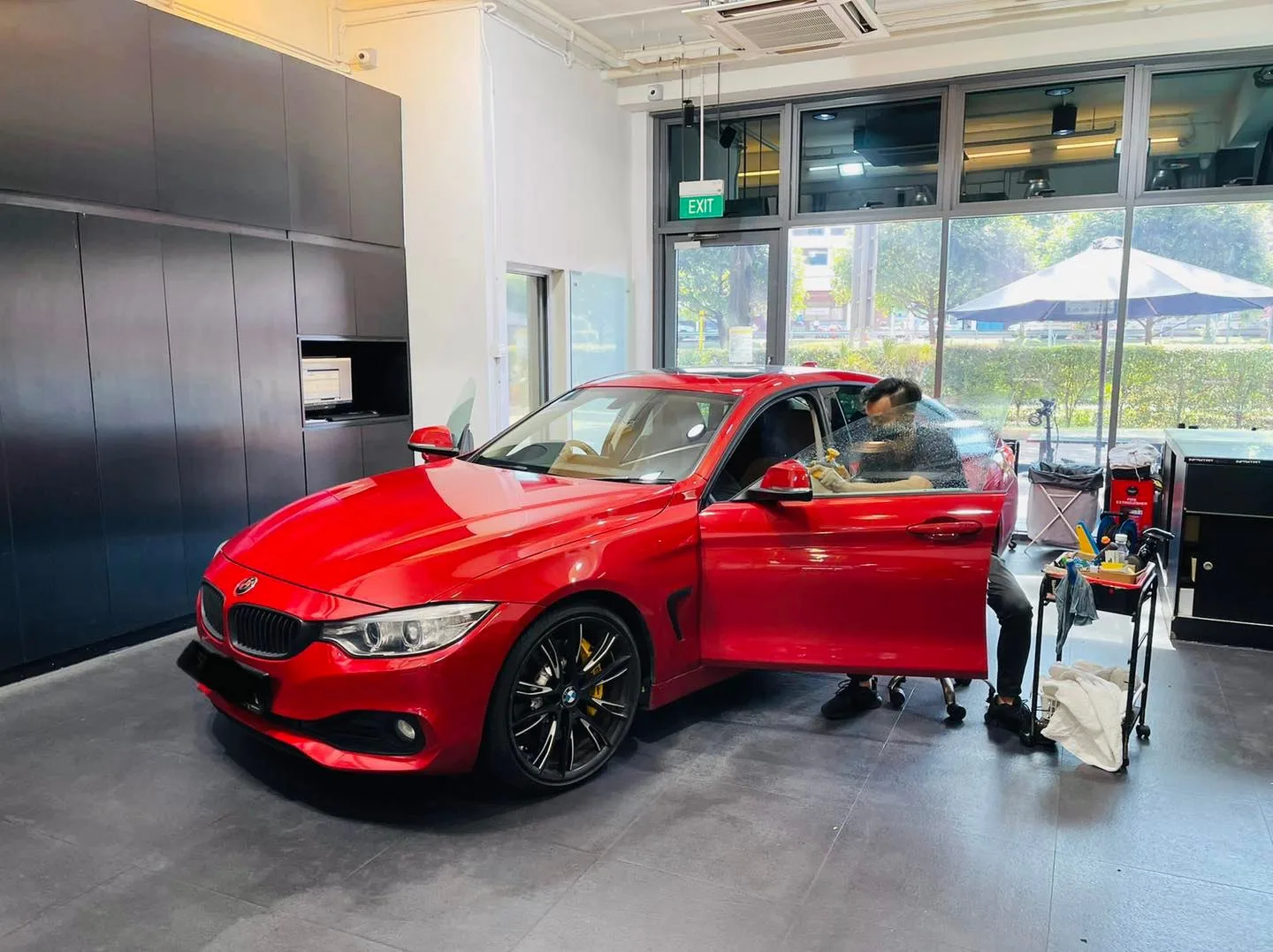 Red BMW coupe being tinted by an installer at Infratint Singapore