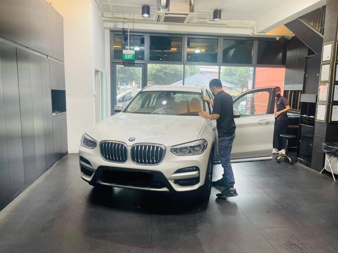 White BMW X3 SUV with an installer working at the open driver door at Infratint Singapore