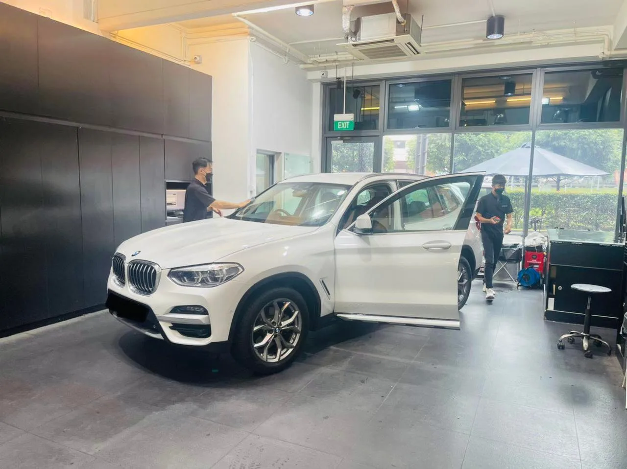 White BMW X3 with doors open during window tinting at Infratint Singapore
